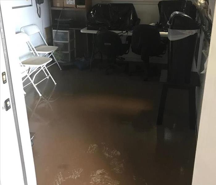 A back room in a store with a few inches of water from a flood covering the floor
